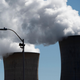 Steam rises out of the nuclear plant on Three Mile Island with an American flag in the foreground.
